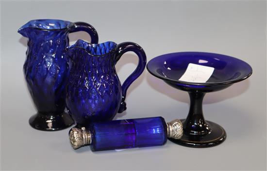 Two George III honeycomb moulded blue glass jugs, a blue glass double ended scent bottle and an early 19th century dish